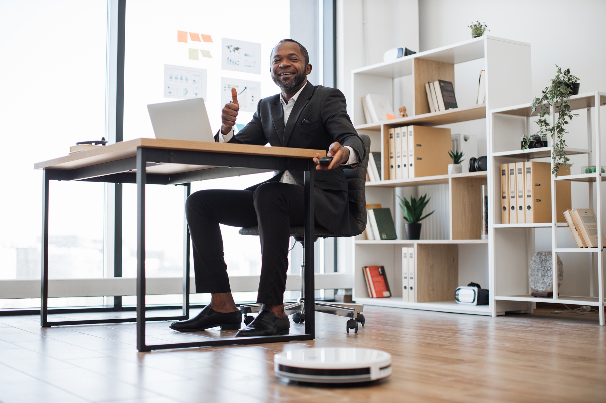 Entrepreneur switching on robot vacuum cleaner at work